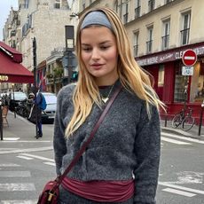  @sabinasocol wearing a dark gray cardigan with a red top underneath on the streets of Paris.