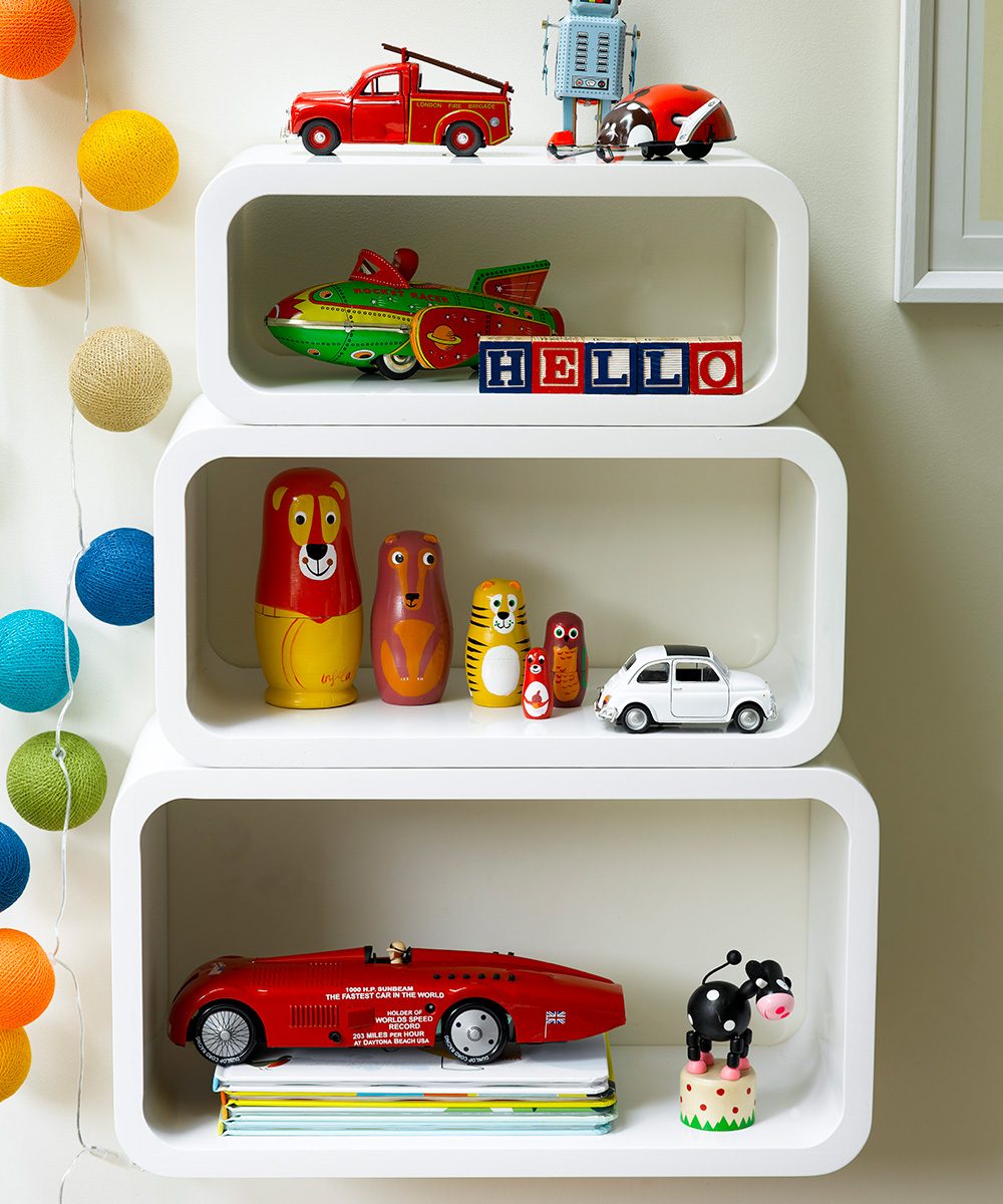 Cube-style white wall shelves filled with colorful kids' toys.