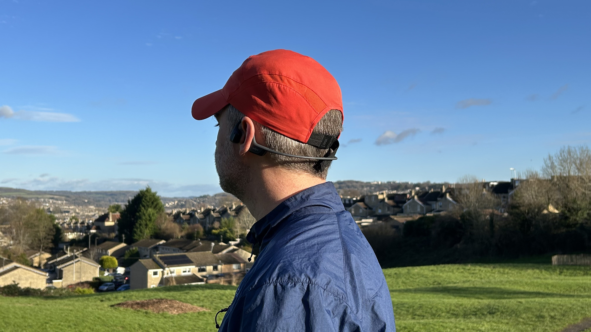 The reviewer wearing the Shokz OpenRun Pro 2 headphones while looking over Bath on a clear day