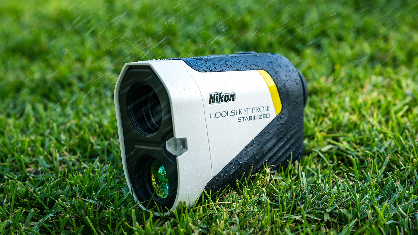 A Nikon laser rangefinder on grass during rain