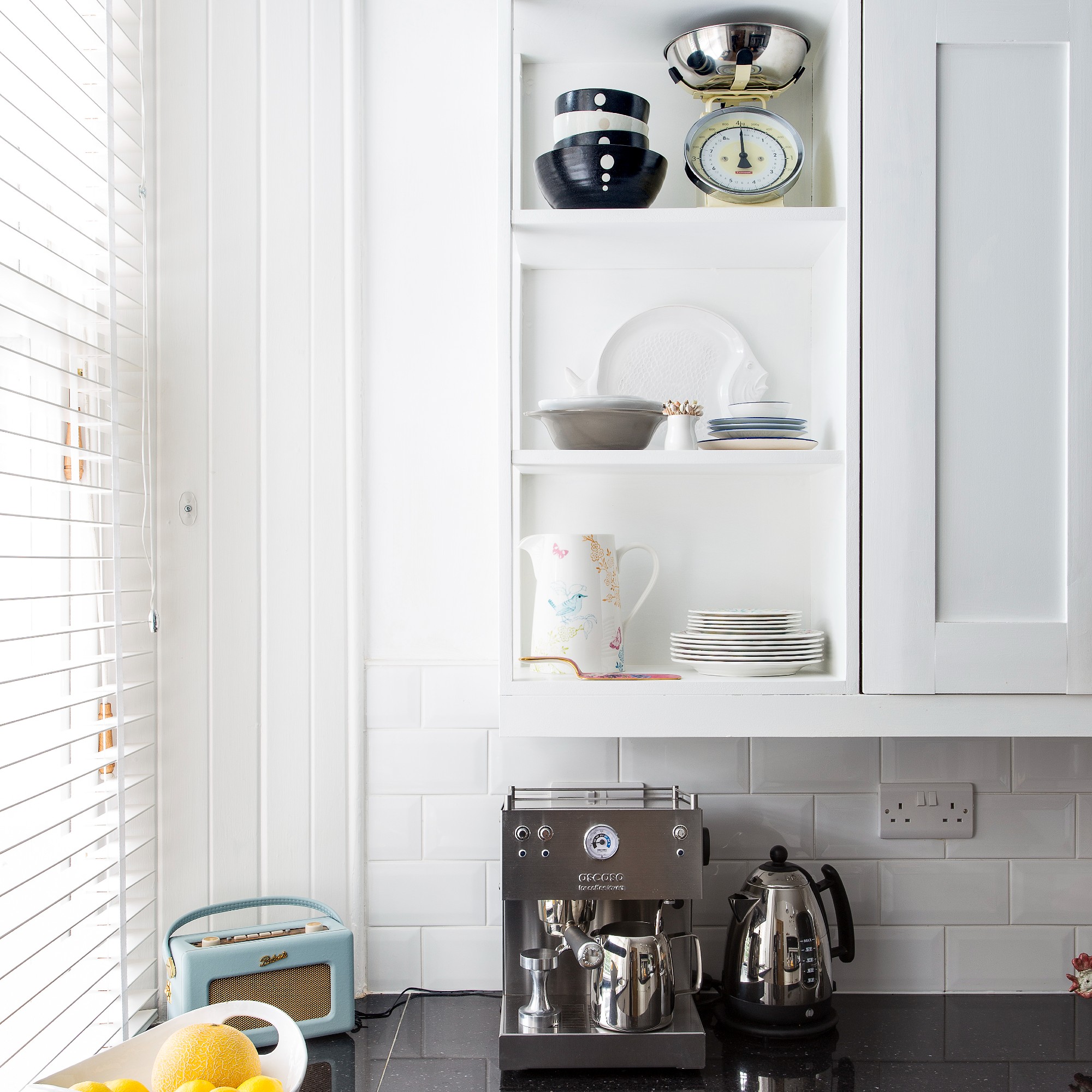 A white kitchen with silver-toned coffee machine and kettle