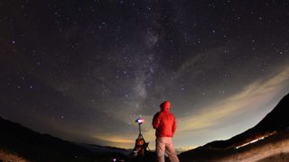 Man and telescope underneath the milky way