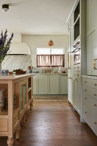 cozy kitchen with timber island bench and cafe curtain windows