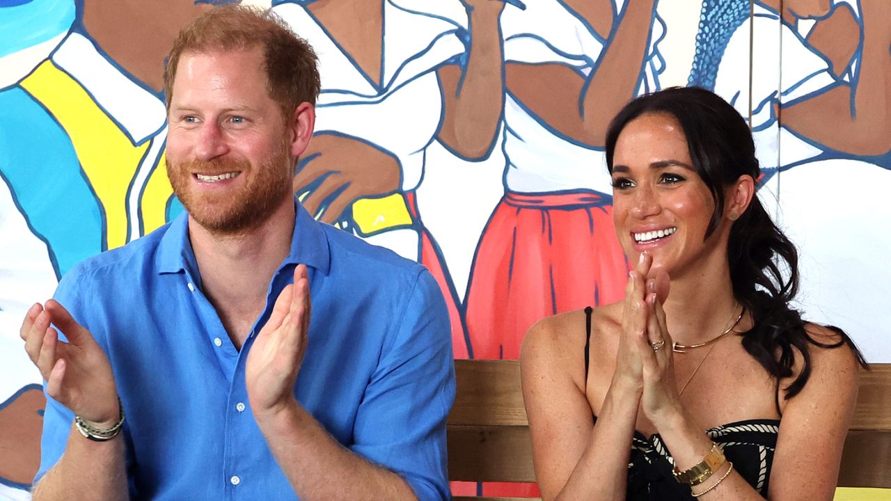 Prince Harry and Meghan Markle clap and laugh while visiting the Escuela Tambores de Cabildo in Cartagena, Colombia