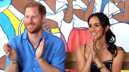 Prince Harry and Meghan Markle clap and laugh while visiting the Escuela Tambores de Cabildo in Cartagena, Colombia