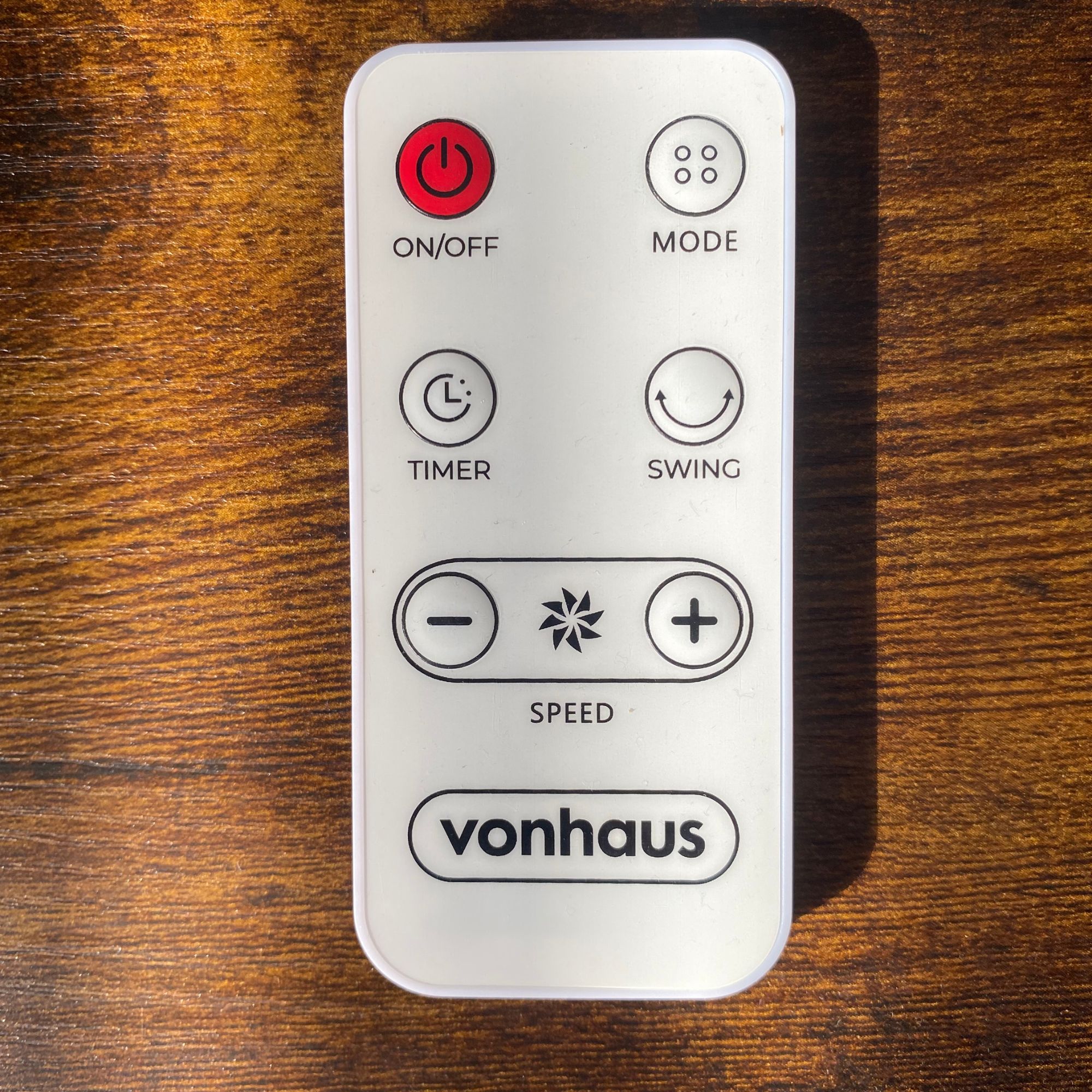 Remote control of the Vonhaus Air Circulator Cooling Fan on a wooden side table