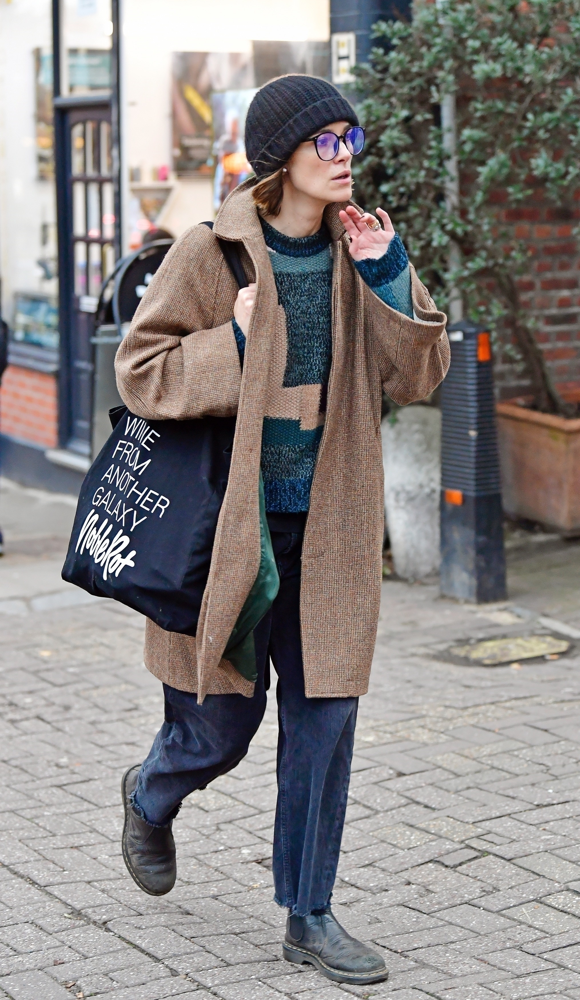 Keira Knightley wears a brown coat and jeans
