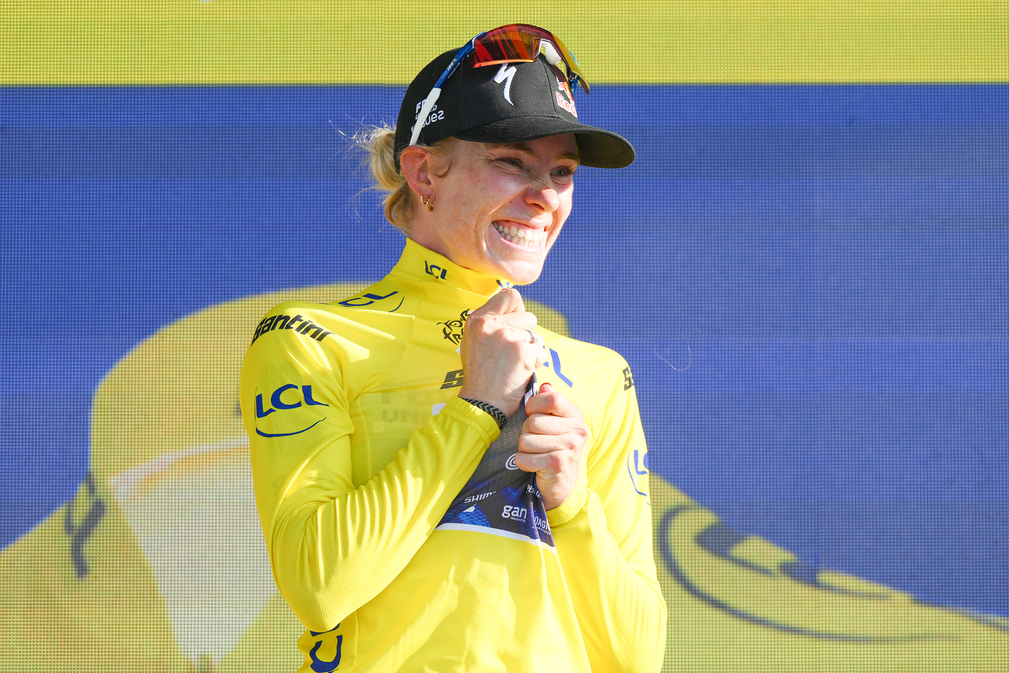 Demi Vollering wearing the yellow jersey on the podium