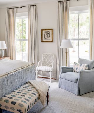 blue and white bedroom with a bench and seating area with soft lighting