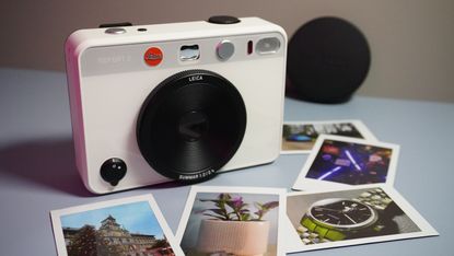 The Leica Sofort 2 in white, surrounded by instant film snaps