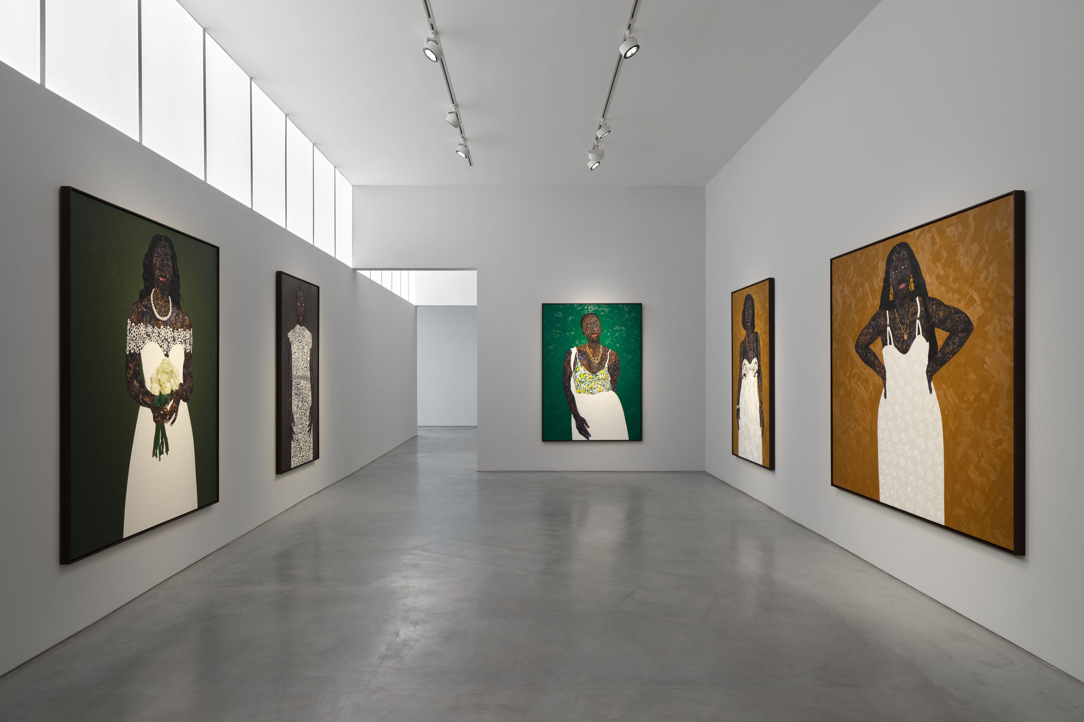 View of an art gallery installation with dark wood walls and multiple expressive portrait paintings. In the foreground, a large black metal structure with vertical bars frames additional paintings inside, while more portraits hang on the walls in the background.