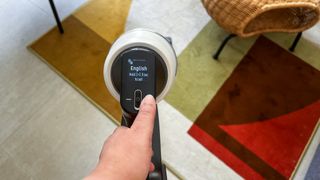 Hand holding the Samsung Bespoke Jet AI cordless vacuum as it begins its initial setup