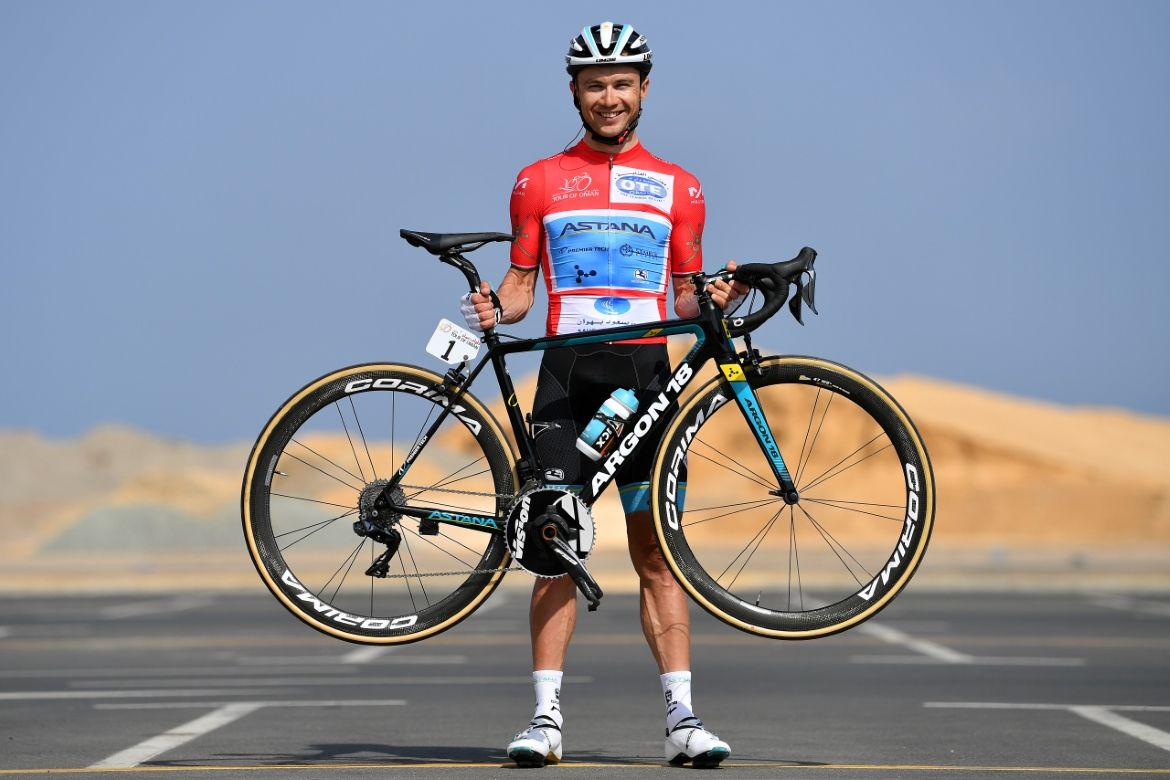 Alexey Lutsenko (Astana) shows off his bike and his red race winner's jersey