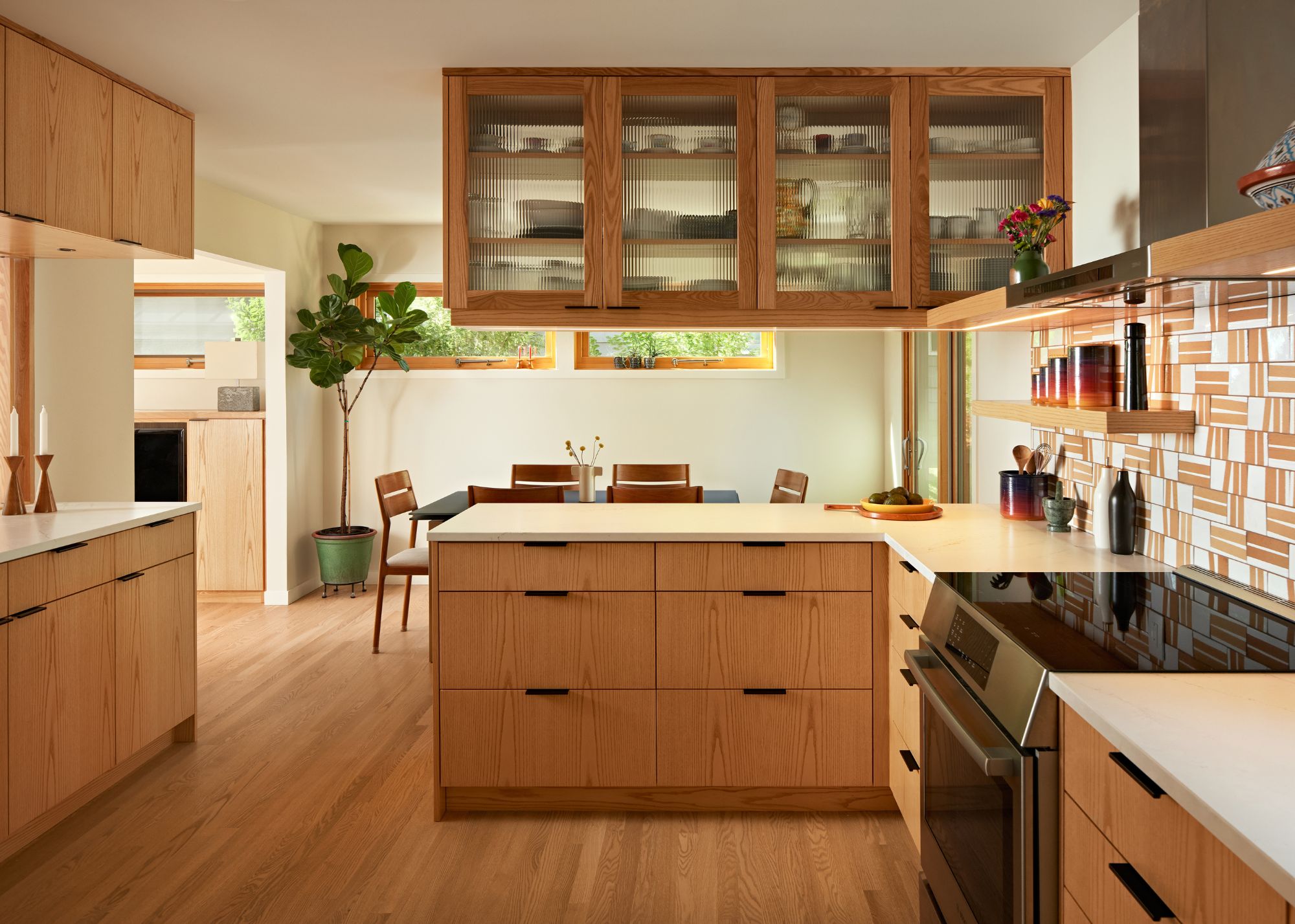 A kitchen with wooden flooring, wooden cabinets and peninsula with storage above