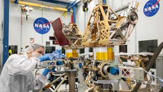 Engineers in white suits assemble and test NASA's first robotic Moon rover in a clean room at NASA's Johnson Space Center in Houston.