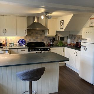 Kitchen with white cabinets, island with grey countertop