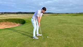 A golfer hitting a wedge shot into the third at Royal Troon