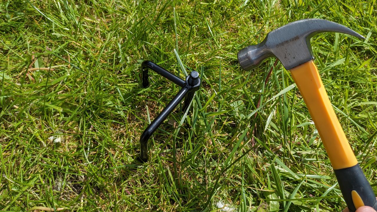 Using a hammer to bed in the i105E aerial's staked base