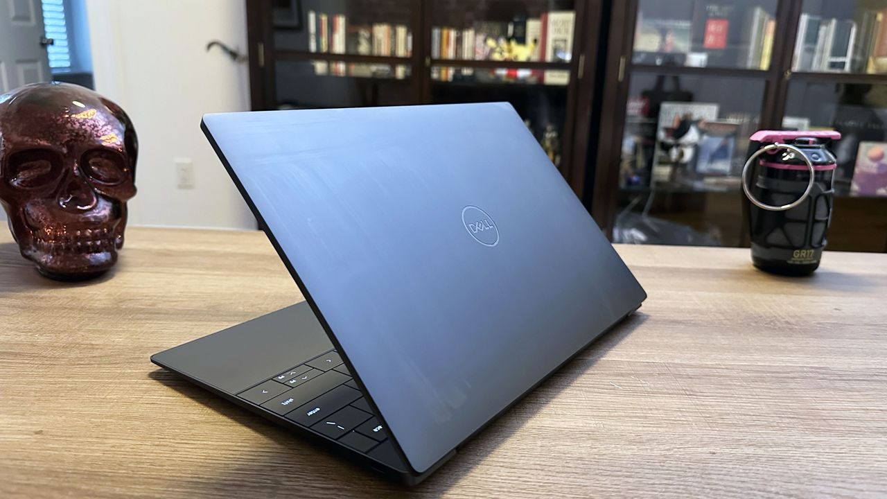 Dell XPS 13 (9350) angled on a wooden desk showing the lid.