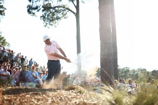 Scottie Scheffler strikes a shot from the trees