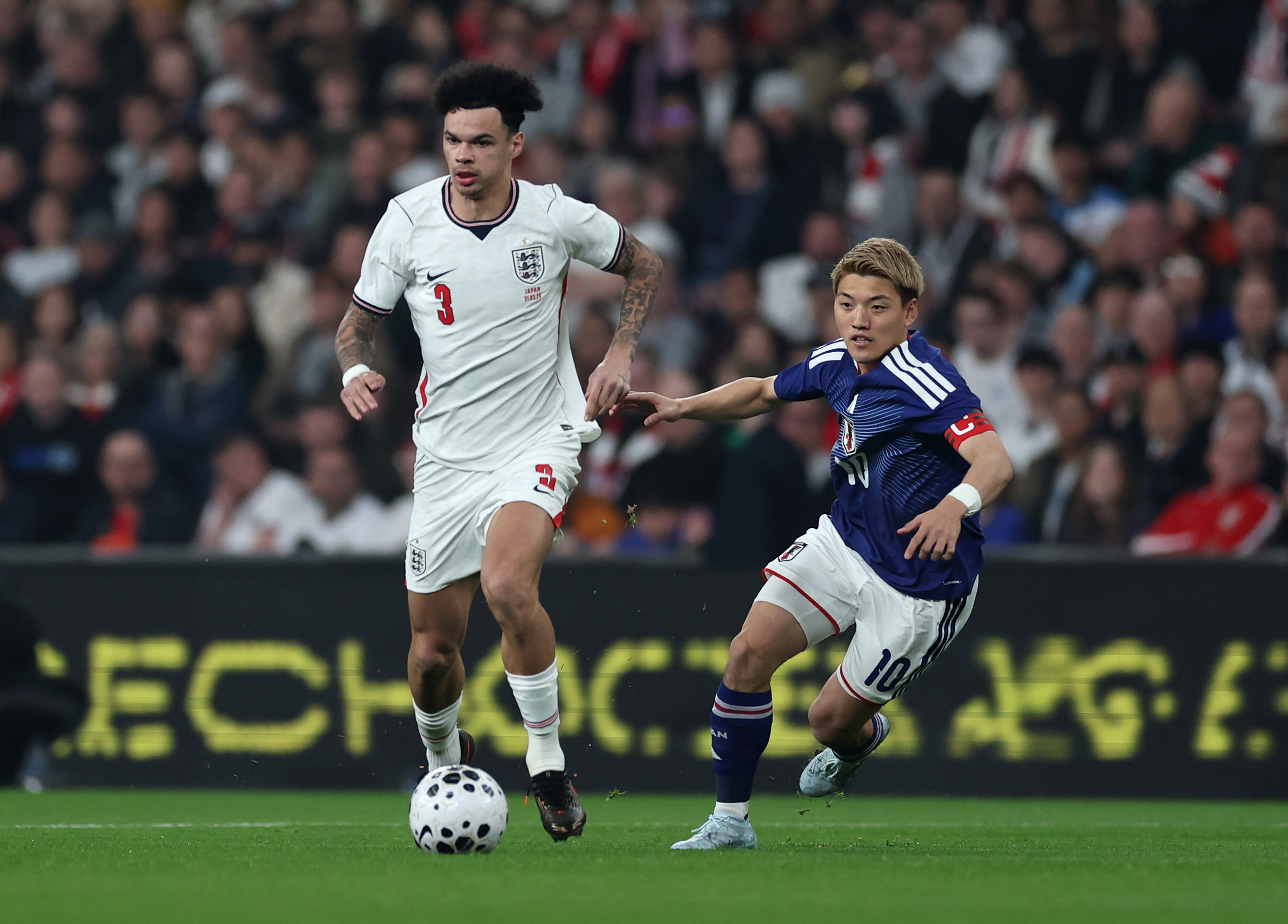 Nico O'Reilly of England is put under pressure by Ritsu Doan of Japan during the international friendly match between England and Japan at Wembley Stadium on March 31, 2026 in London, England.