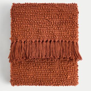 rust coloured boucle throw with tassel trim