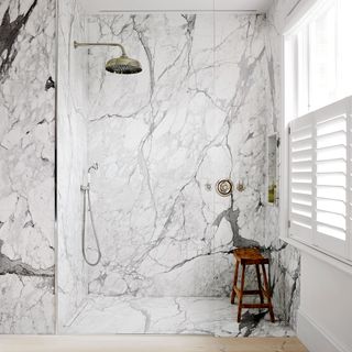 Marble walk-in shower with gold shower head