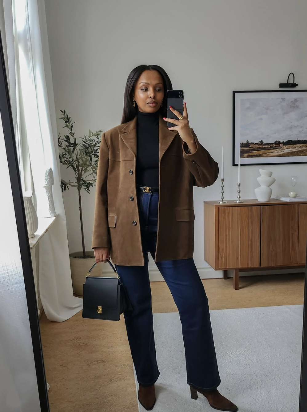 woman wearing dark wash jeans and a brown suede blazer
