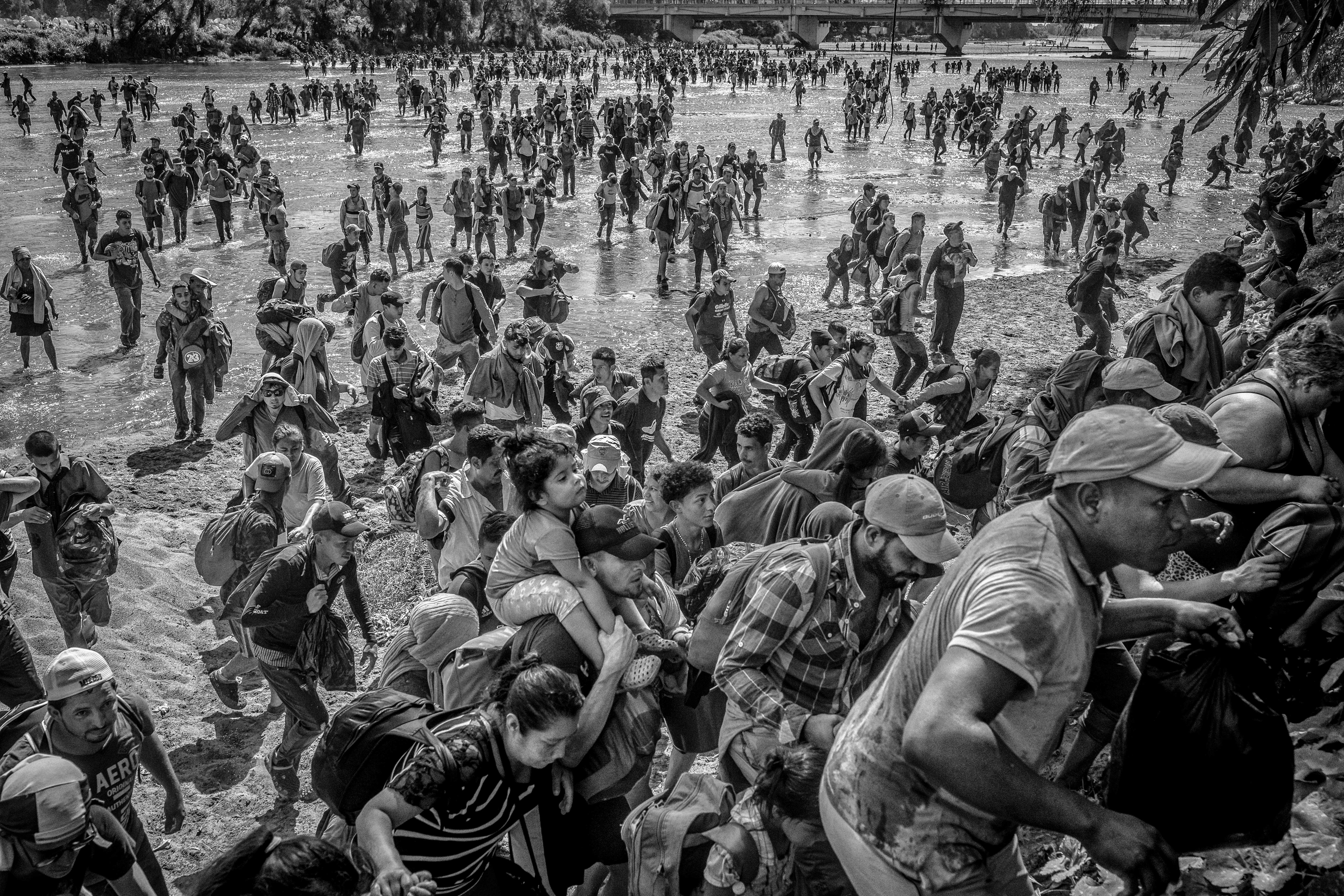 Ever Sosa carries his daughter on his shoulders as they cross the Suchiate River from Guatemala to Mexico, Mexico 2020. From the series “The Two Walls”