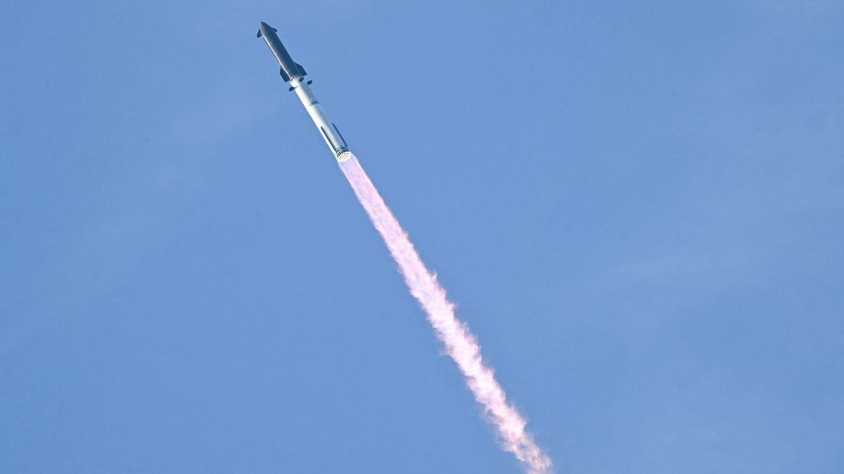 a rocket launches against a light blue sky.