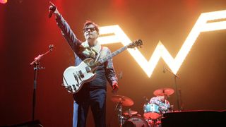 Rivers Cuomo in front of a light-up Weezer sign at the 2020 Innings Festival at Tempe Beach Park, AZ