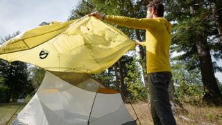 Man putting the rain fly on the Nemo Dagger Osmo tent