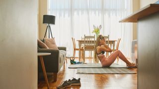 Woman performs sit-up exercise at home