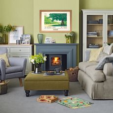 green living room with grey carpet armchair fireplace and valspar paint