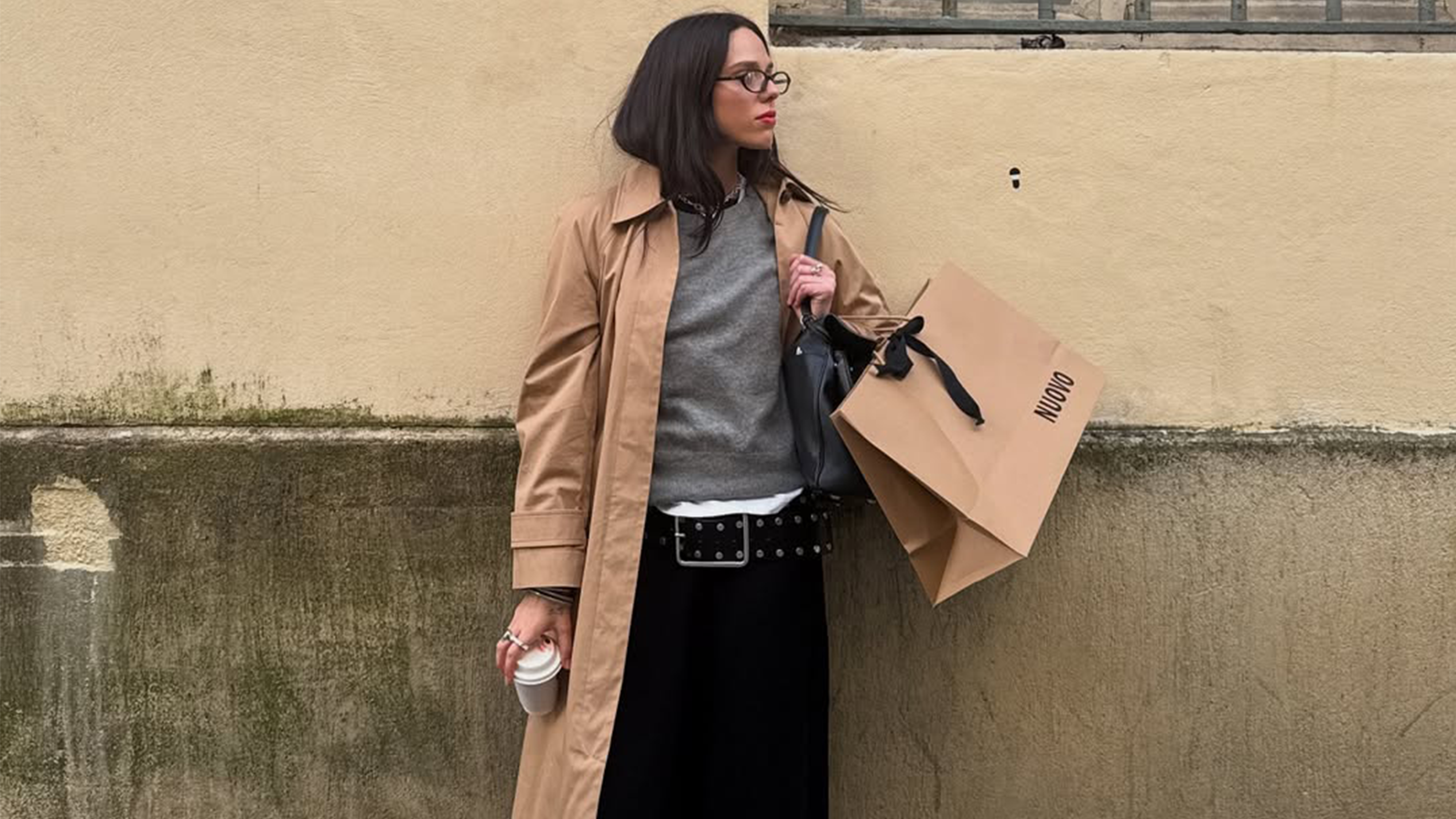 Lucy McFadin wearing a trench coach and glasses with a gray top.