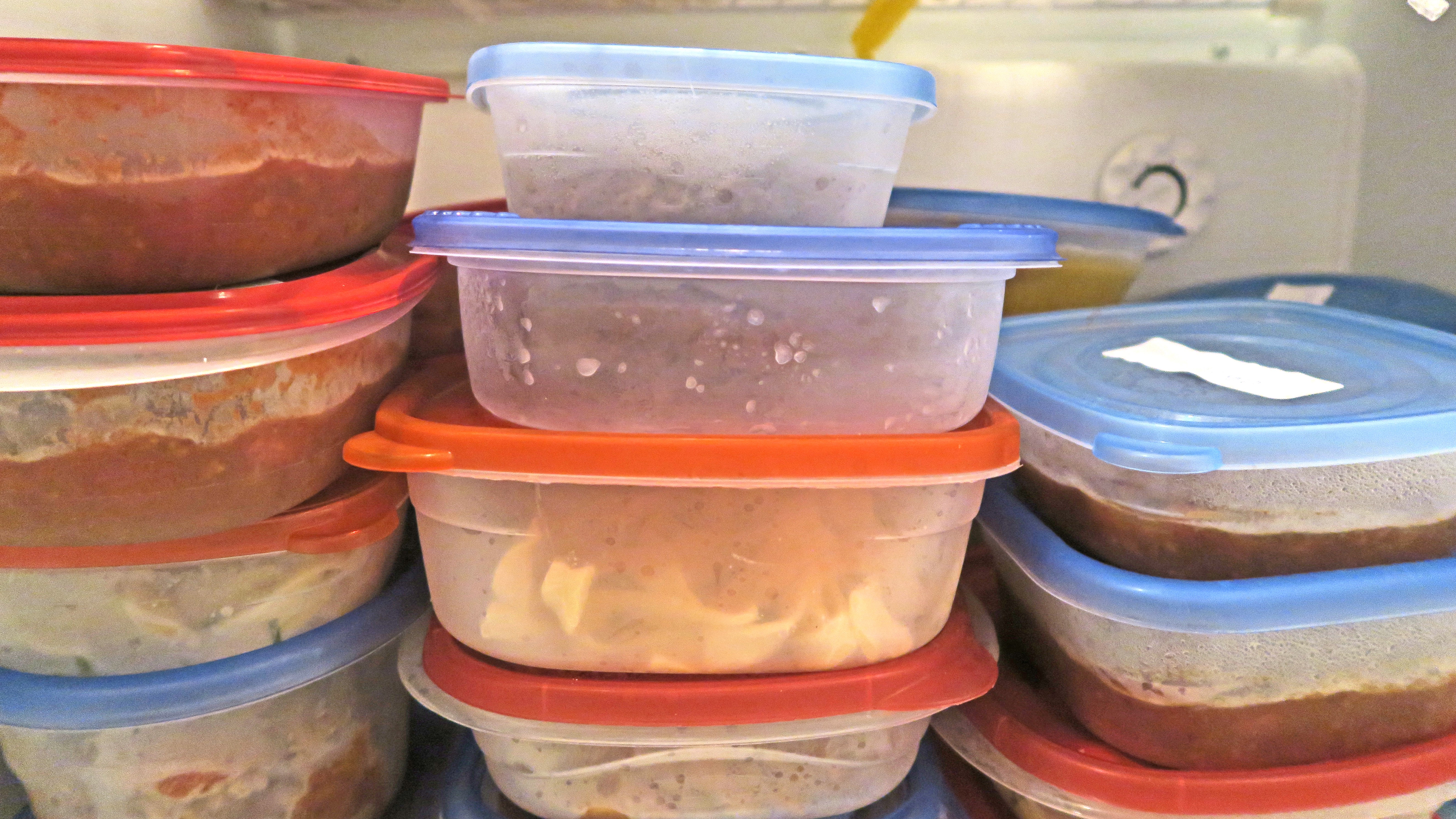 Containers full of leftover food in freezer