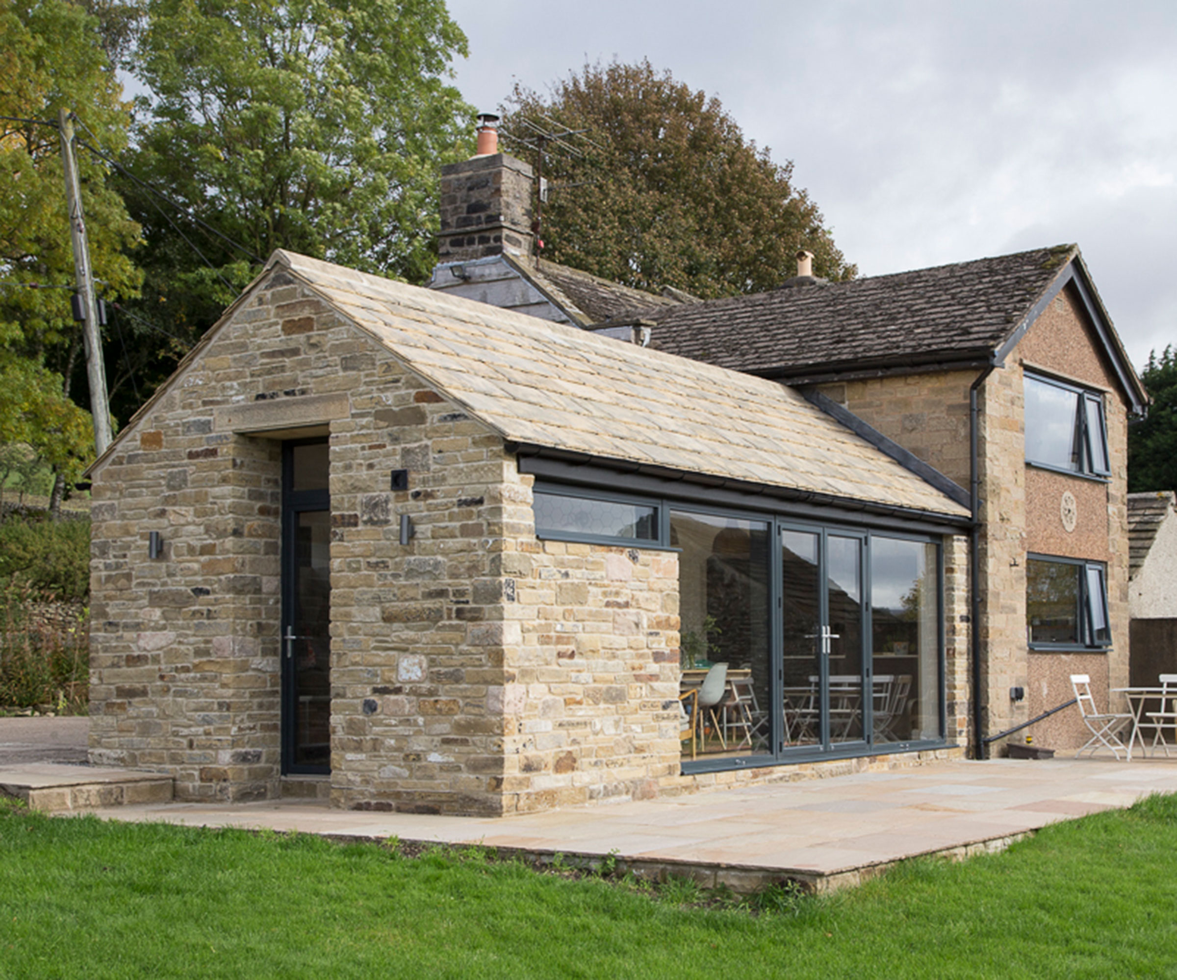 a stone-clad single-storey extension built from structural insulated panels