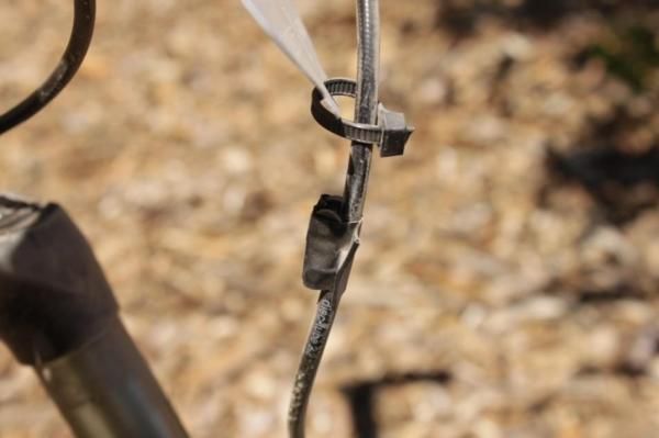 A spare master link for the SRAM PC-1 chain is taped to the front brake line.
