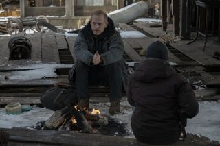 (L to R) Scott Shepherd as David in front of a fire and Bella Ramsey as Ellie in The Last of Us Episode 8