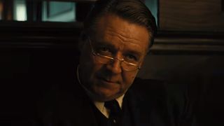A close up of Russell Crowe looking over his glasses in Unabomber