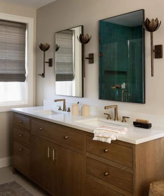 Beige bathroom with double sink and wall lights