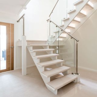 A staircase with glass panels and steel handrails