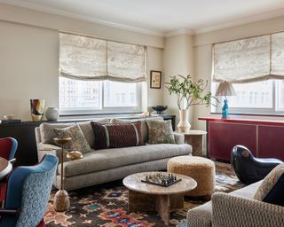 Living room with round coffee tables, neutral sofa, area rug, and edge of dining table and chairs