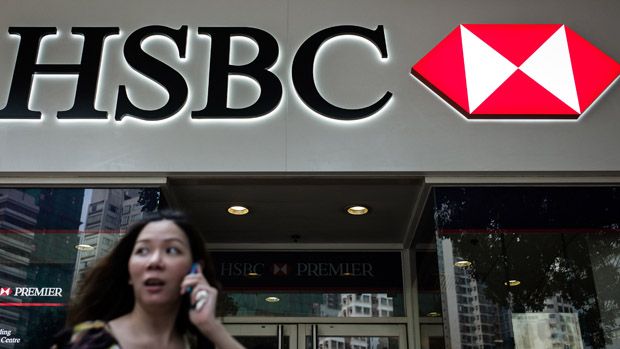 A woman talks on the phone near a branch of HSBC bank