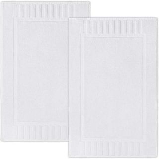 Two white rectangle bath mats next to one another on a white background