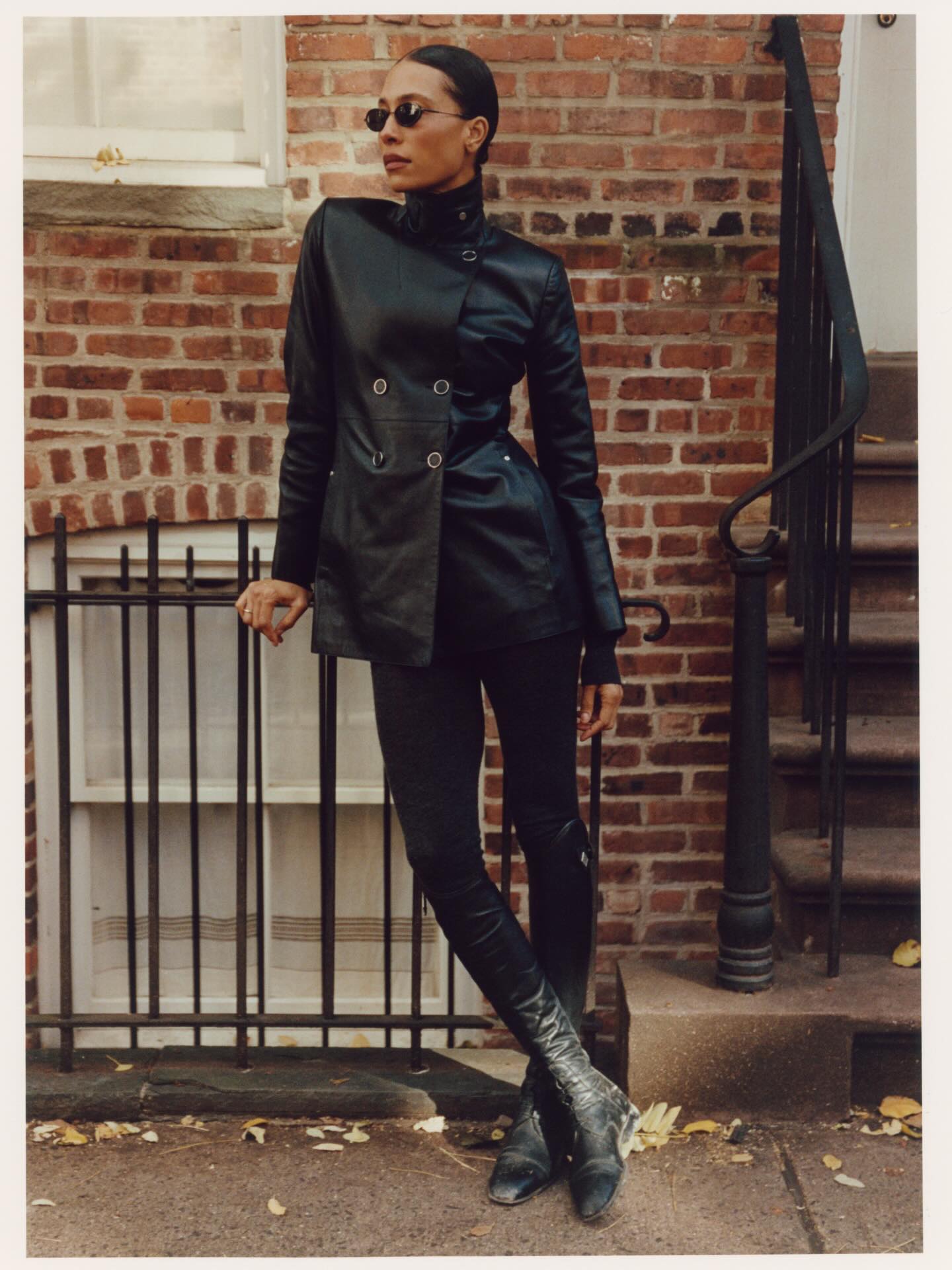 An image of @tylynn wearing full-length leggings with riding boots and a funnel-neck leather jacket, one of the biggest trends to wear with leggings in 2026.