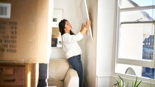 Woman hanging up a picture