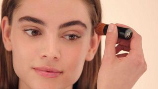 Model applying Chanel bronzer with brush