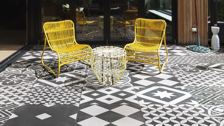 monochrome patchwork patio tiles and yellow seating