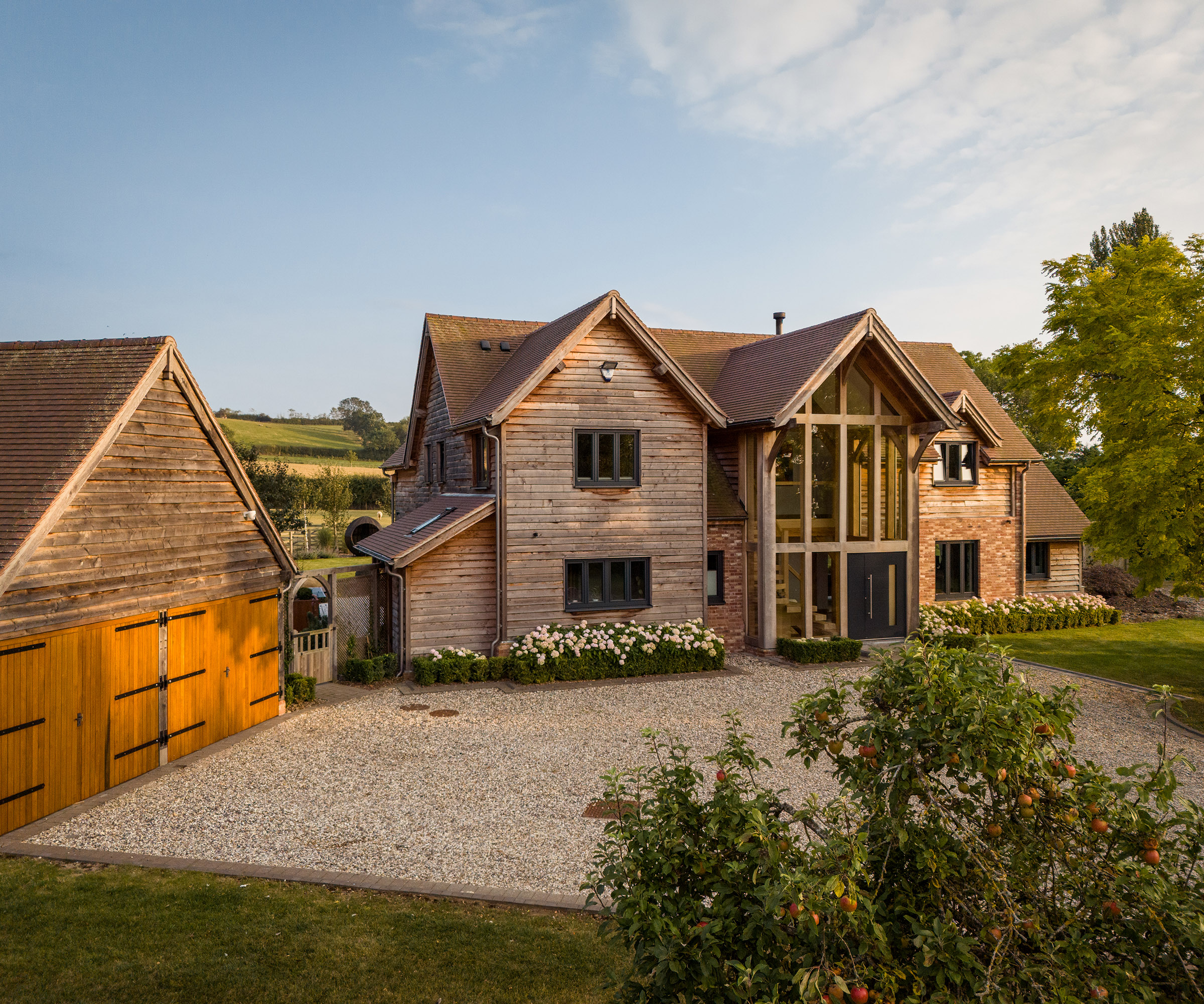 A large detached oak frame self-build with garage and gravel driveway